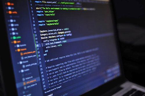 A laptop displaying a screen of coding language